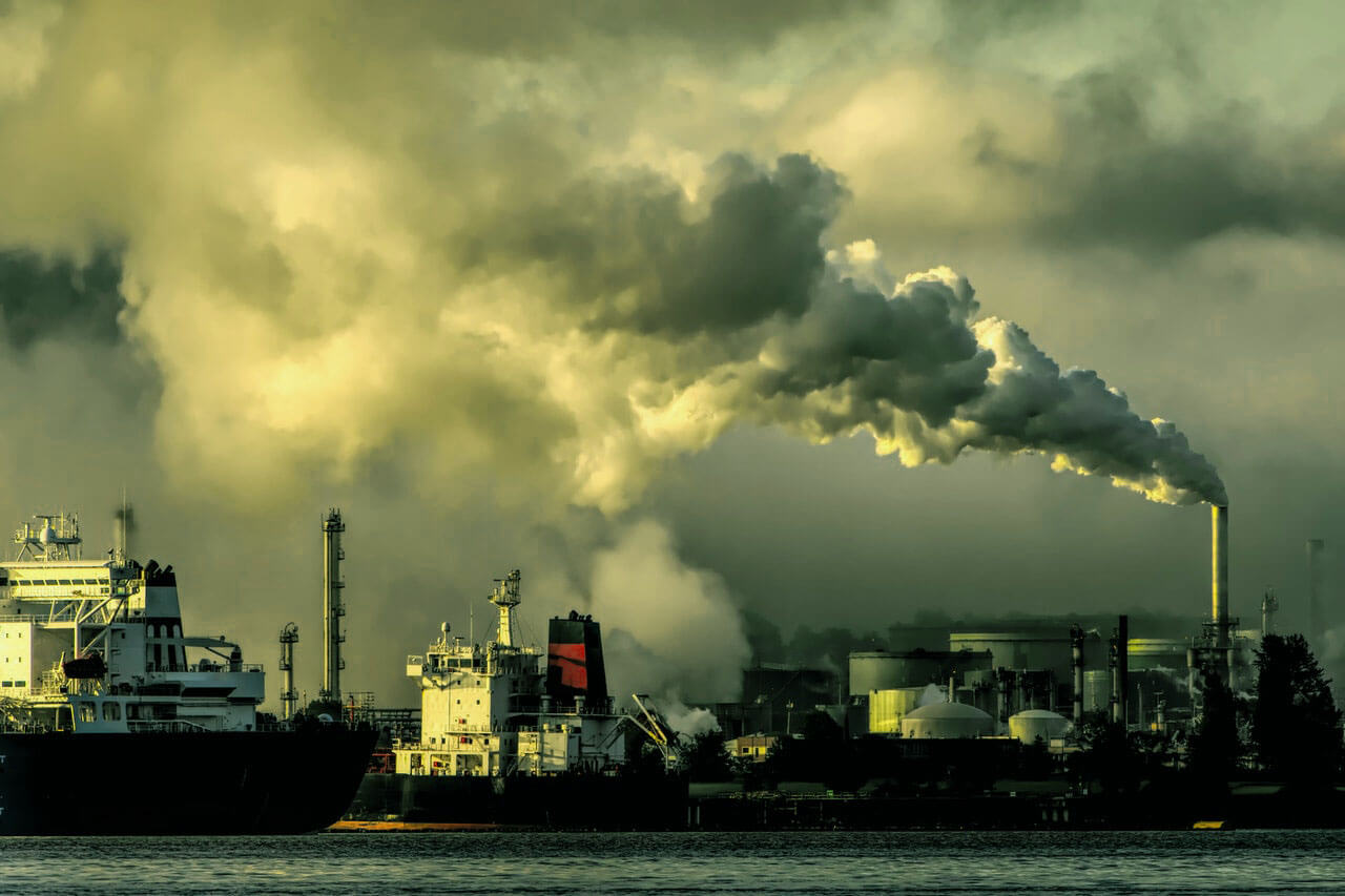 Gases de efeito estufa sendo emitido na atmosfera por chaminés de fábrica