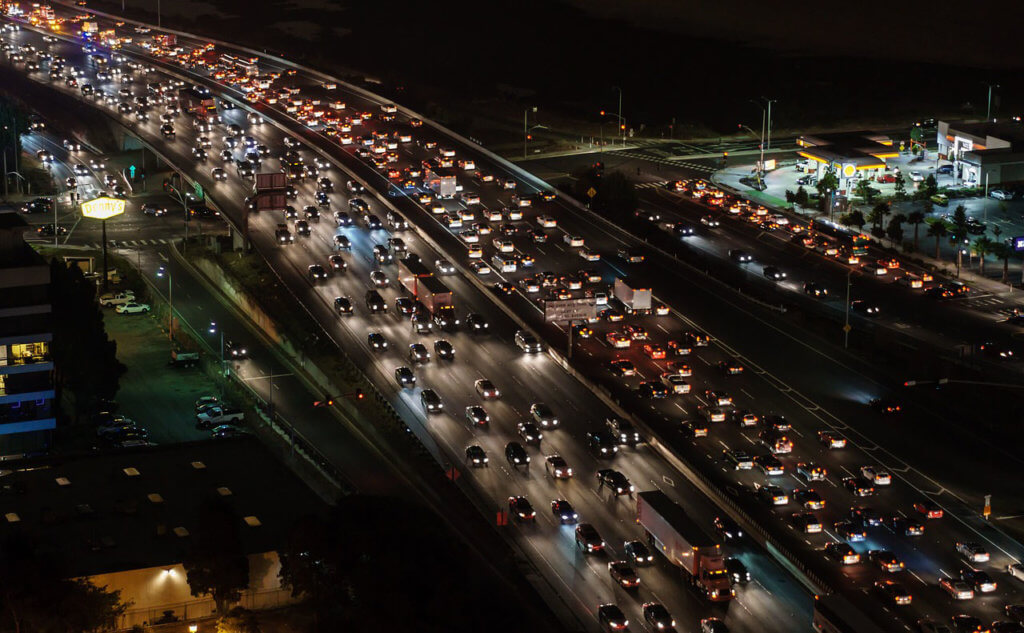 Rodovia mostrando engarrafamento noturno nos dois sentidos do tráfego.