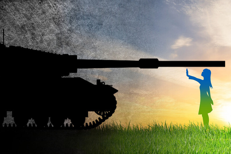 Imagem de um tanque de guerra em um campo aberto e gramado sendo parado por uma jovem para ilustrar se a guerra na Ucrânia vai estimular ou atrasar a energia verde na Europa.