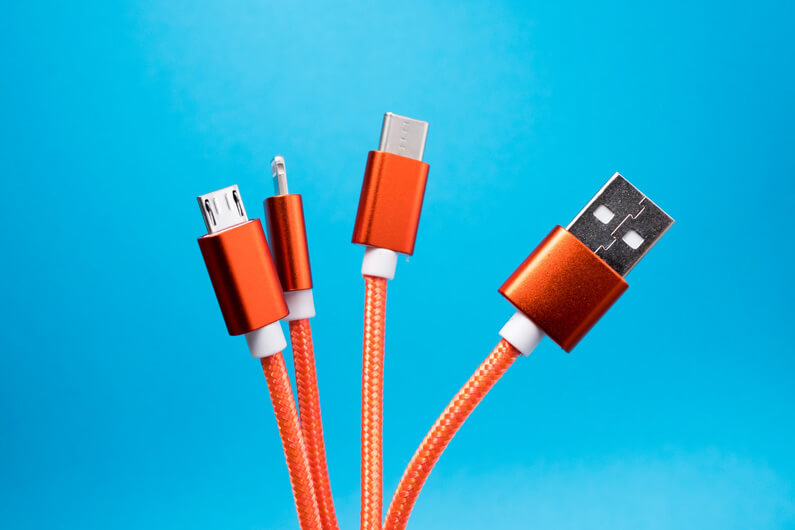 Imagem de quatro cabos de com conexões diferentes para ilustrar que nova regra da União Europeia vai exigir padronização para carregadores de celular.
