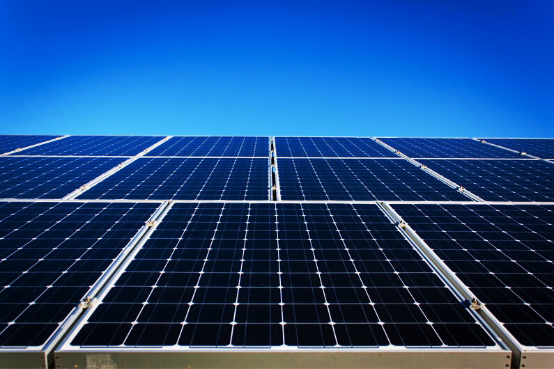 Imagem de painéis fotovoltaicos sobre um fundo mostrando o céu azul para ilustrar por que a sustentabilidade é crucial para a estratégia corporativa.