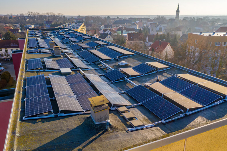 Foto de um prédio com painéis solares no topo para ilustrar que a França aprova lei que exige painéis solares em estacionamentos. Foto: Solarimo/Pixabay