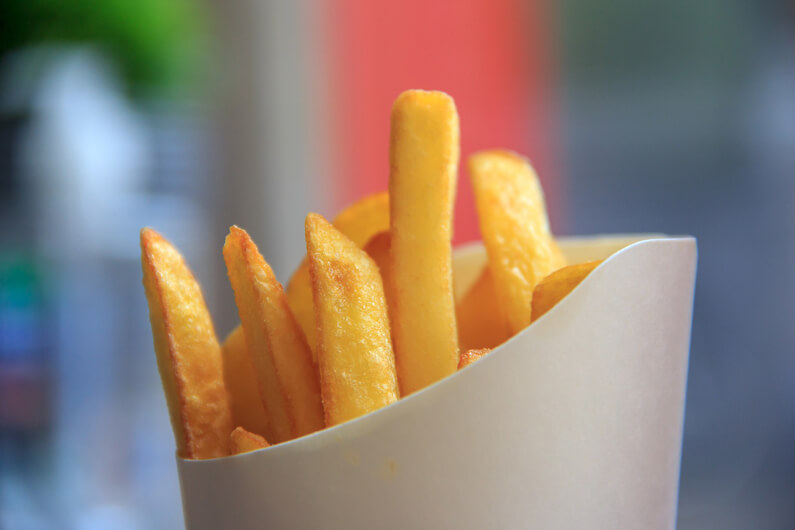 Imagem de batatas fritas dentro de um pequeno recipiente de papel para ilustrar que as PFAS estão em todo lugar e são altamente tóxicas para humanos.