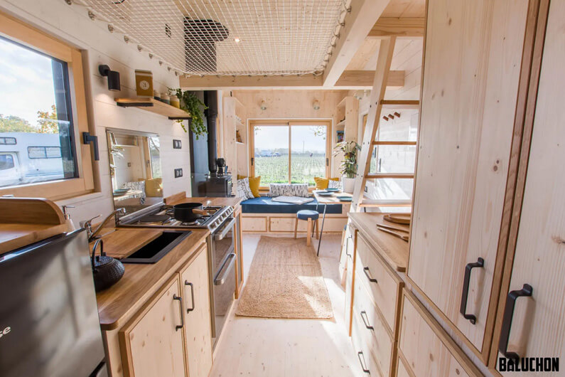 Foto interna da sala e cozinha de uma pequena casa para ilustrar que layouts inteligentes otimizam espaços de casas minimalistas.