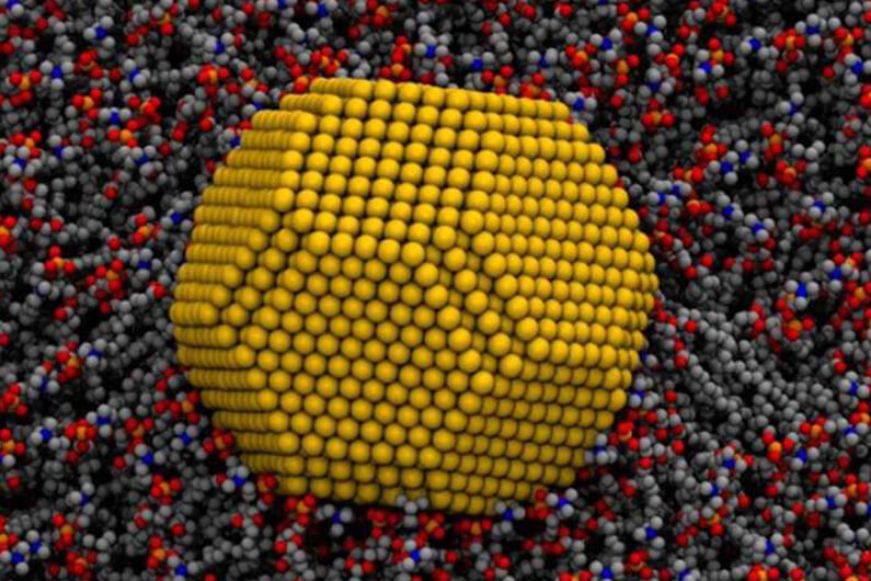 Imagem computadorizada de uma nano partícula de ouro sobre uma membrana celular para ilustrar que a nano medicina tem potencial para curar doenças incuráveis.