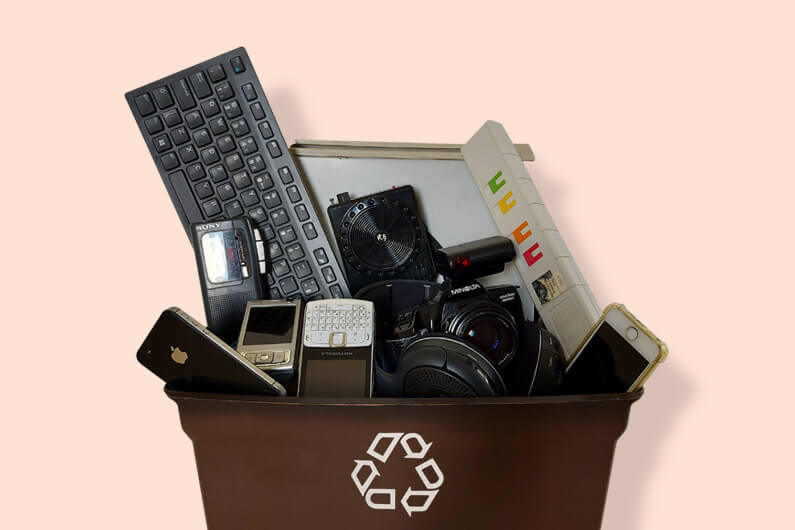 Foto de uma lixeira transbordando dos mais diversos aparelhos eletrônicos como forma de ilustrar que reciclar lixo eletrônico é uma oportunidade econômica enorme.