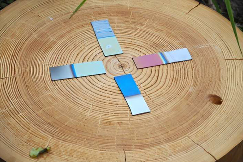 Imagem de uma mesa redonda de madeira com 4 filmes de lignina ilustram artigo intitulado Película oriunda da madeira mantém óculos e para-brisas limpos.