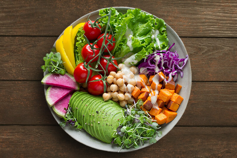 Imagem de um prato vegano cheio de legumes, verduras e grãos para ilustrar artigo cujo título diz que um estudo raro de Stanford afirma que dieta vegana melhora a saúde.