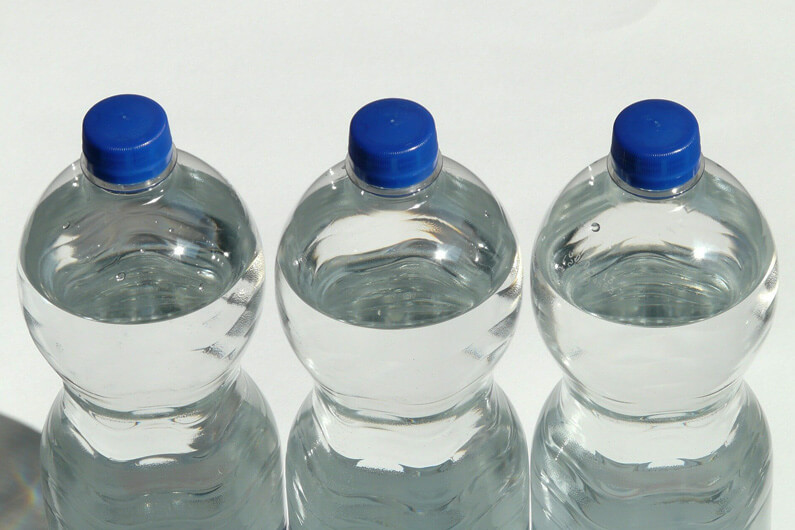 Imagem de três garrafas de água mineral juntas ilustra post cujo título diz que resíduos de polietileno podem ser uma coisa do passado.