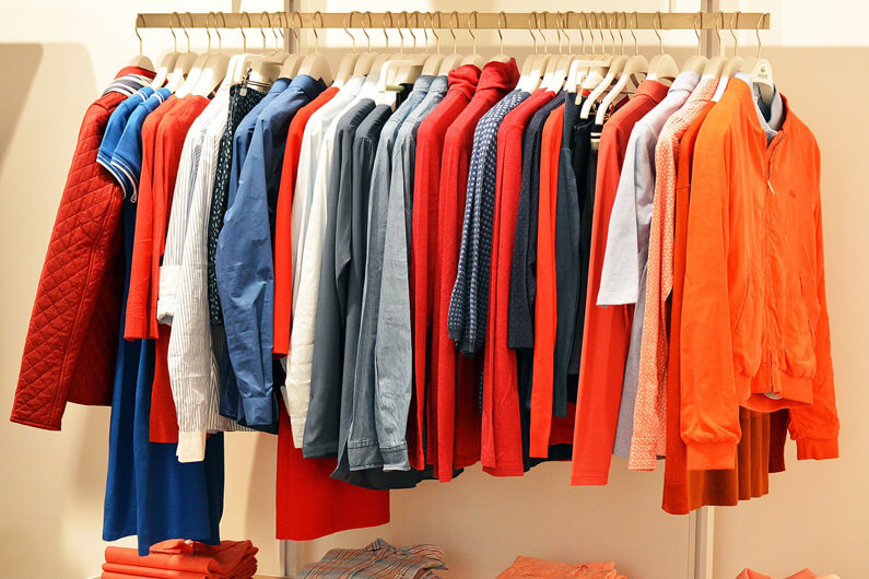 Imagem de um cabideiro cheio de roupas de segunda mão ilustra o post cujo título diz que o mercado de roupas usadas cresceu 7X nos EUA em 2023.