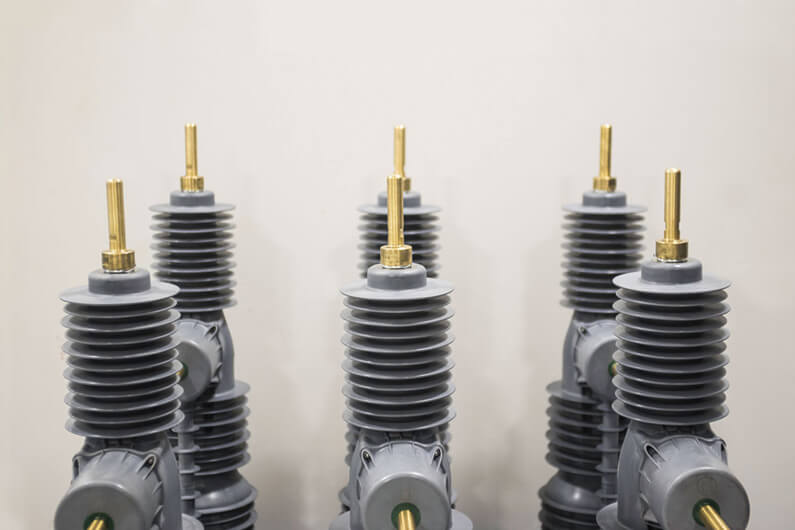 Imagem de três religadores sobre um fundo bege ilustra o artigo que aborda como um aparelho compacto pode reduzir as quedas de energia.